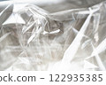Crumpled clear plastic background, abstract glossy broken surface texture with creases 122935385