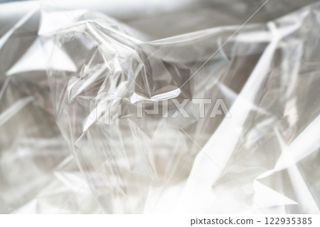 Crumpled clear plastic background, abstract glossy broken surface texture with creases Crumpled clear plastic background, abstract glossy broken surface texture with creases 122935385