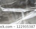 Crumpled clear plastic background, abstract glossy broken surface texture with creases 122935387