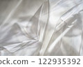 Crumpled clear plastic background, abstract glossy broken surface texture with creases 122935392