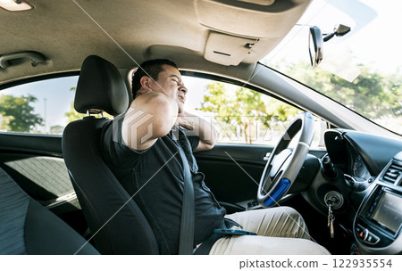 Exhausted driver with pain and stress. Man in the car with neck pain. Exhausted driver with neck pain in traffic, Driver people with neck pain in car Exhausted driver with pain and stress. Man in the car with neck pain. Exhausted driver with neck pain in traffic, Driver people with neck pain in car 122935554