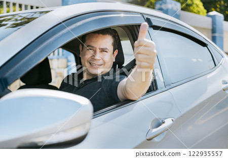 Man in his car giving thumbs up, Happy Driver giving a thumbs up. Satisfied driver man showing thumb up. Concept of satisfied car owner 122935557