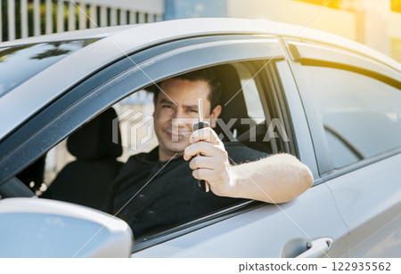 Happy man showing his new car keys, Person in his vehicle showing his car keys, Satisfied car buyer concept, Driver in his car showing the keys out the window 122935562