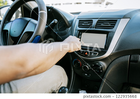 Distracted driver concept tuning the radio. Hand of driver changing radio station, Driver man changing the radio station, Close up of driver tuning into the radio station Distracted driver concept tuning the radio. Hand of driver changing radio station, Driver man changing the radio station, Close up of driver tuning into the radio station 122935668