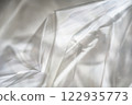 Crumpled clear plastic background, abstract glossy broken surface texture with creases 122935773