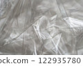 Crumpled clear plastic background, abstract glossy broken surface texture with creases 122935780
