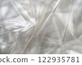 Crumpled clear plastic background, abstract glossy broken surface texture with creases 122935781