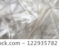 Crumpled clear plastic background, abstract glossy broken surface texture with creases 122935782