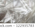 Crumpled clear plastic background, abstract glossy broken surface texture with creases 122935783