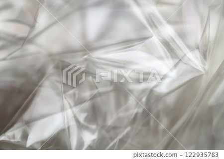 Crumpled clear plastic background, abstract glossy broken surface texture with creases Crumpled clear plastic background, abstract glossy broken surface texture with creases 122935783