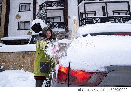 Person Clearing Snow from Car in Winter Landscape Person Clearing Snow from Car in Winter Landscape 122936091
