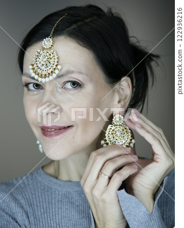Attractive 51 year old woman wearing Indian jewellery posing for the camera Attractive 51 year old woman wearing Indian jewellery posing for the camera 122936216