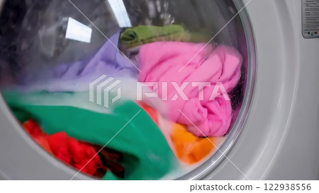 Washing machine washing colorful clothes 122938556