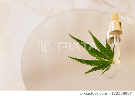 Mock up bottle cosmetic product and pipette with cannabis leaves on white glossy background Mock up bottle cosmetic product and pipette with cannabis leaves on white glossy background 122939997