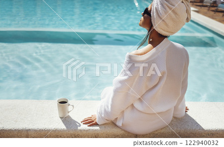 Young pretty woman in a white bathrobe holds a cup of coffee. Young pretty woman in a white bathrobe holds a cup of coffee. 122940032