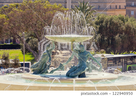 Iconic Triton fountain in Valletta reveals dynamic flow of swirling water, fountain capturing intricate bronze sculpture, fountain symbolizing Maltese heritage: Valletta, Malta - 06.04.2019 Iconic Triton fountain in Valletta reveals dynamic flow of swirling water, fountain capturing intricate bronze sculpture, fountain symbolizing Maltese heritage: Valletta, Malta - 06.04.2019 122940950
