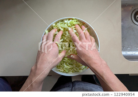 Hands vigorously tossing shredded cabbage in large bowl, salad becoming bright symbol of fresh nutrition, salad capturing crisp texture, salad perfect for quick healthy lunches Hands vigorously tossing shredded cabbage in large bowl, salad becoming bright symbol of fresh nutrition, salad capturing crisp texture, salad perfect for quick healthy lunches 122940954