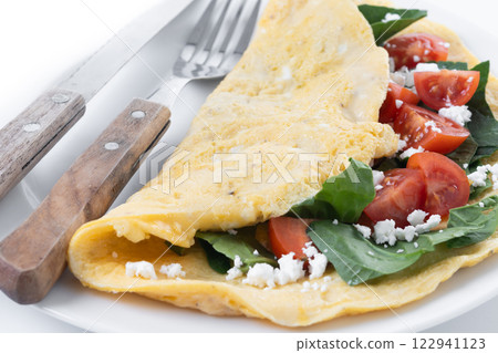 Stuffed omelette with tomatoes and spinach isolated on white background Stuffed omelette with tomatoes and spinach isolated on white background 122941123