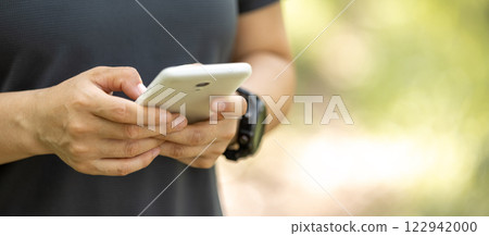Hands using mobile phone  in summer forest 122942000