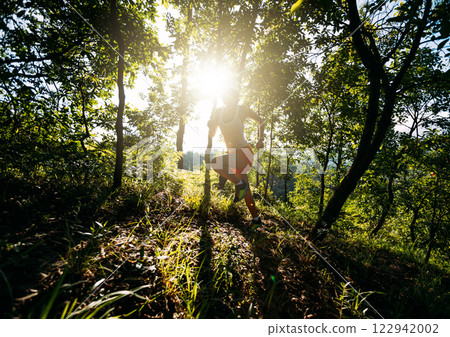 Woman runner running on forest trail Woman runner running on forest trail 122942002