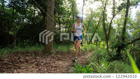 Woman runner running on forest trail Woman runner running on forest trail 122942010