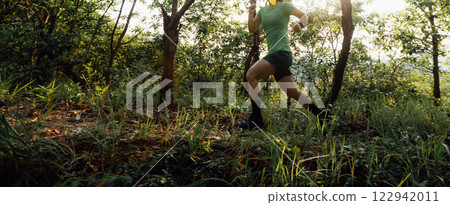 Trail runner running in summer forest trail Trail runner running in summer forest trail 122942011
