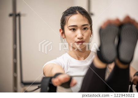 在室內健身房做機器普拉提的年輕女子 122943022