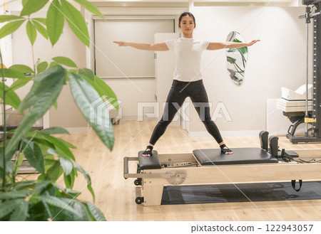 在室內健身房做機器普拉提的年輕女子 122943057