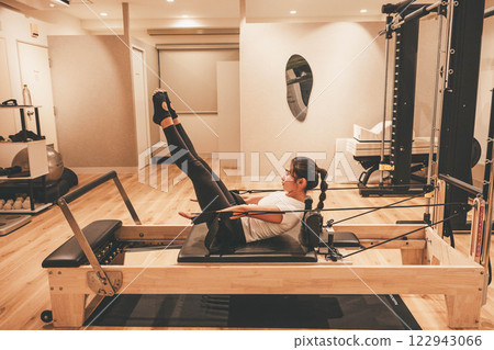 在室內健身房做機器普拉提的年輕女子 122943066