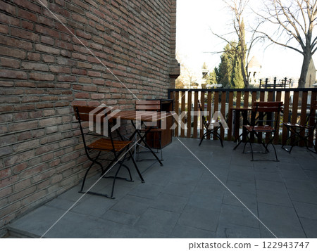 City cafe on street with wooden chairs and tables City cafe on street with wooden chairs and tables 122943747