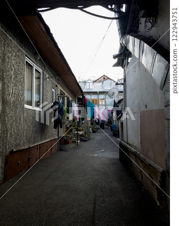 Cozy courtyard with clean laundry drying on warm day Cozy courtyard with clean laundry drying on warm day 122943751
