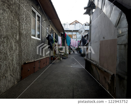 Walking narrow street along clean clothes drying on ropes 122943752