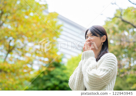 公園裡，一位身穿白色針織衫、微笑的日本女性 122943945