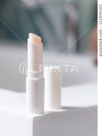 Opened white blank lip balm stick on basin in tropical bathroom close up, cosmetic mockup Opened white blank lip balm stick on basin in tropical bathroom close up, cosmetic mockup 122944103