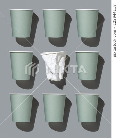 New light green paper cups and crumpled used white one on a gray top view,  hard shadow 122944118