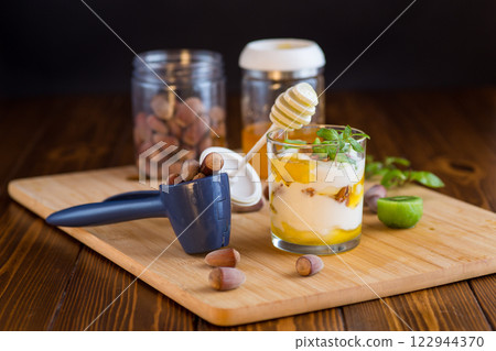 homemade yogurt with kiwi, honey and nuts in a glass on a wooden table 122944370
