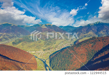 Aerial view of the mountain valley with the river and the small town of Kolochava on a sunny day. Mountain view in autumn. Beautiful natural landscape. Carpathian mountains. Ukraine 122944515