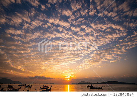 Amazing colorful clouds in sunset or sunrise sky over sea nature landscape background Amazing colorful clouds in sunset or sunrise sky over sea nature landscape background 122945054