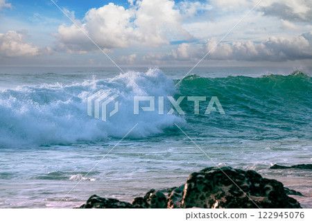 The wave rolls over the rocky shore 122945076