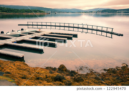 Panoramic view at fjord with boat pier during sunset. Norway Panoramic view at fjord with boat pier during sunset. Norway 122945470
