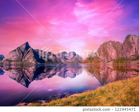 Fjord at sunset. Rocky seashore in the evening with beautiful reflection.  Beautiful nature of Norway. Picturesque Scandinavian landscape. Lofoten islands, Norway, Europe 122945471