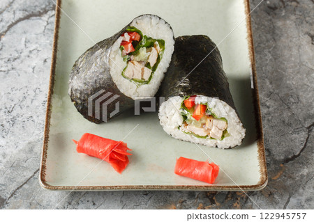 Original hearty snack Sushirrito with rice, chicken breast, cream cheese, vegetables, nori and lettuce close-up in a plate. horizontal Original hearty snack Sushirrito with rice, chicken breast, cream cheese, vegetables, nori and lettuce close-up in a plate. horizontal 122945757