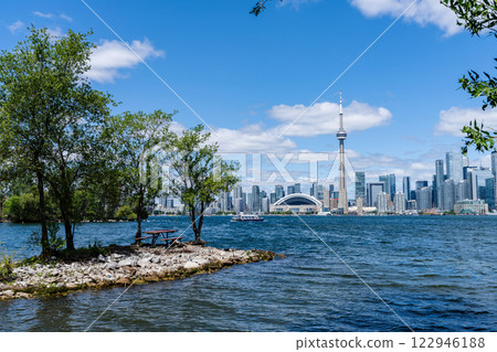 Toronto Island Park Wooden Bench. Toronto City downtown skyline in the background. Ontario, Canada. Toronto Island Park Wooden Bench. Toronto City downtown skyline in the background. Ontario, Canada. 122946188