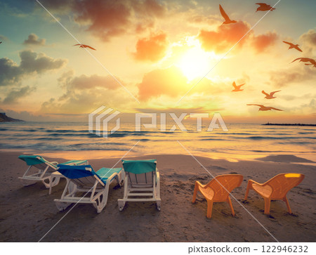 Seascape in the evening. Beach in the evening with chaise lounges Seascape in the evening. Beach in the evening with chaise lounges 122946232