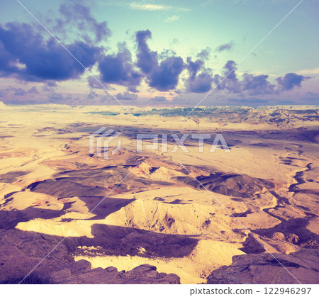 View of mountain valley. Desert with cloudy sky. Makhtesh Ramon Crater in Negev desert, Israel View of mountain valley. Desert with cloudy sky. Makhtesh Ramon Crater in Negev desert, Israel 122946297