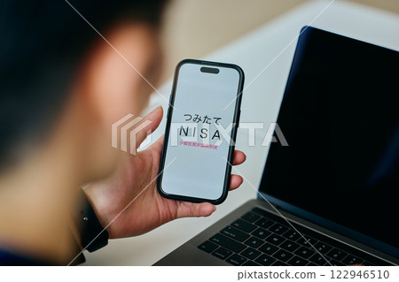 A young man in his twenties operating a smartphone 122946510