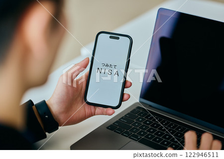 A young man in his twenties operating a smartphone 122946511