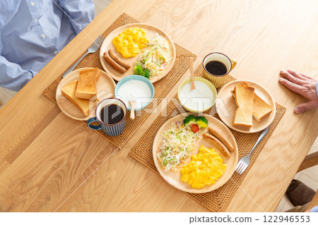 A middle-aged couple eating a Western-style breakfast 122946553
