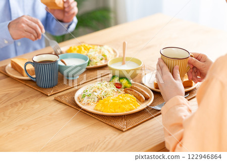 A middle-aged couple eating a Western-style breakfast 122946864