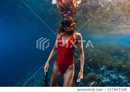 Beauty woman swims underwater in the blue lake. 122947106